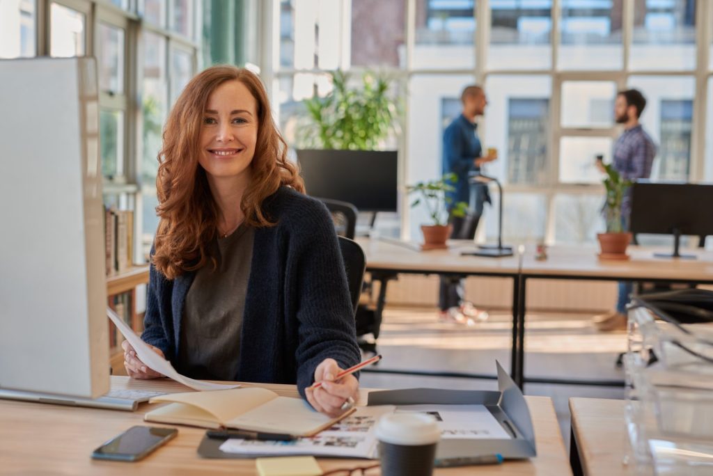 Smiling remote team member working at a desk in a bright office